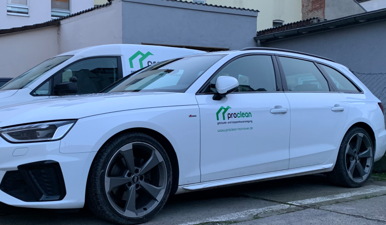 Treppenhausreinigung Hannover Weißer Audi Sportwagen neben einem weißen Lieferwagen Caddy SA vor einem Gebäude, beide Wagen mit dem Logo von Proclean versehen.